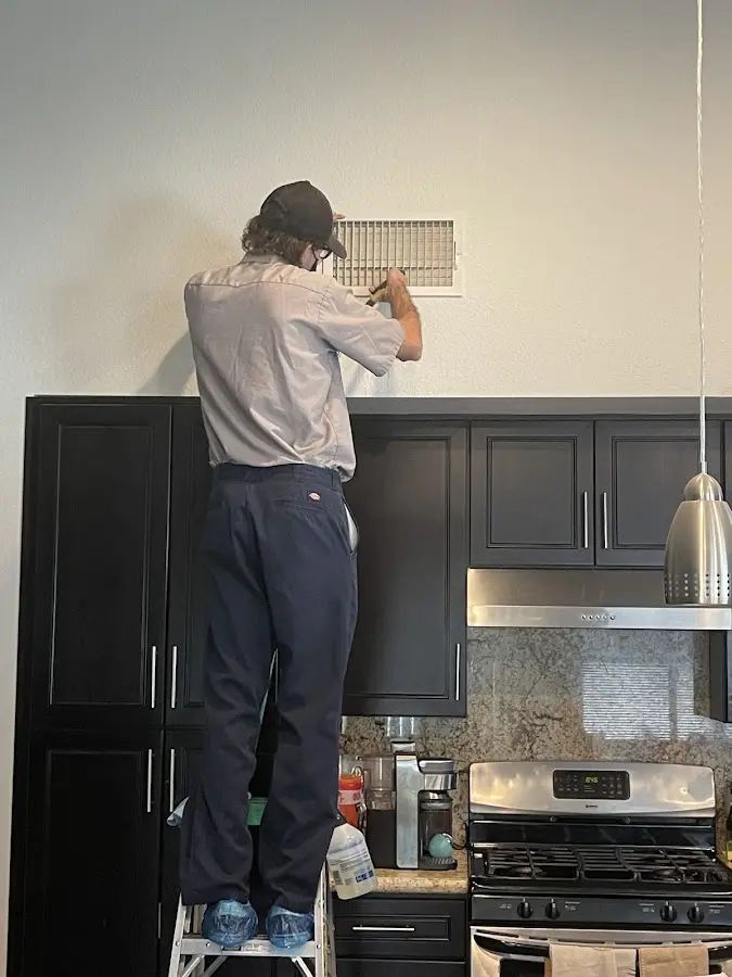 Technician inspecting an air vent during HVAC service in Westmont